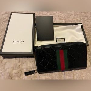 Gucci Wallet Black leather embossed with Web, zip closure.